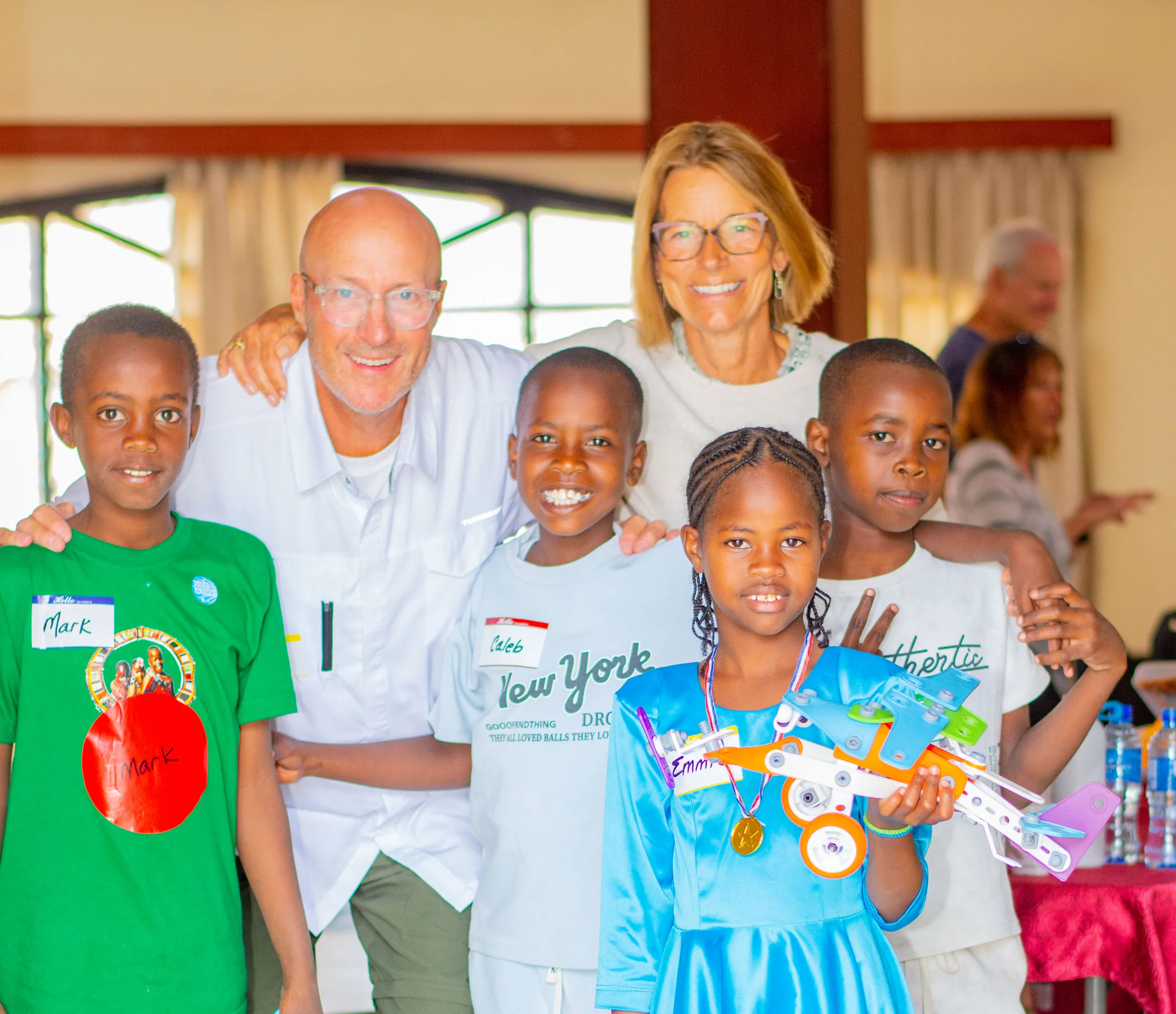 Two supporters with four Amboseli students, one holding a toy aeroplane